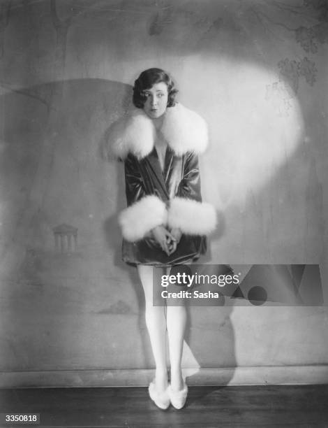 Actress Margaret Campbell wearing a fur-trimmed outfit with matching slippers.