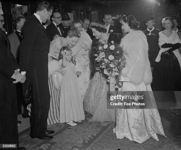 Auriol, the five year old daughter of actress, Phyllis Calvert, meeting Queen Elizabeth , Queen Consort to King George VI outside the Empire Theatre,...