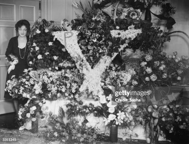 Silent film star Pauline Frederick of Madame X fame with floral tributes including one in the shape of an X.