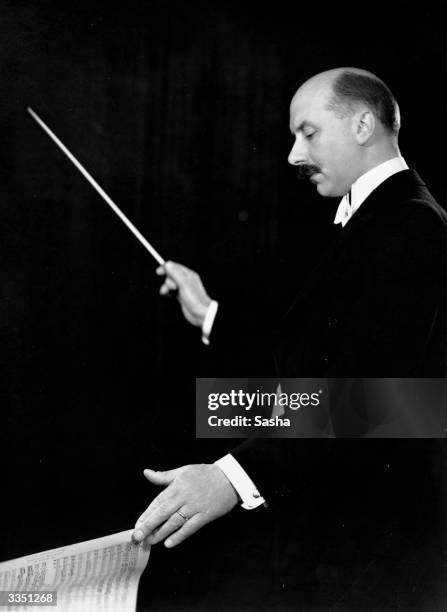 English conductor Sir Adrian Boult holding his baton.