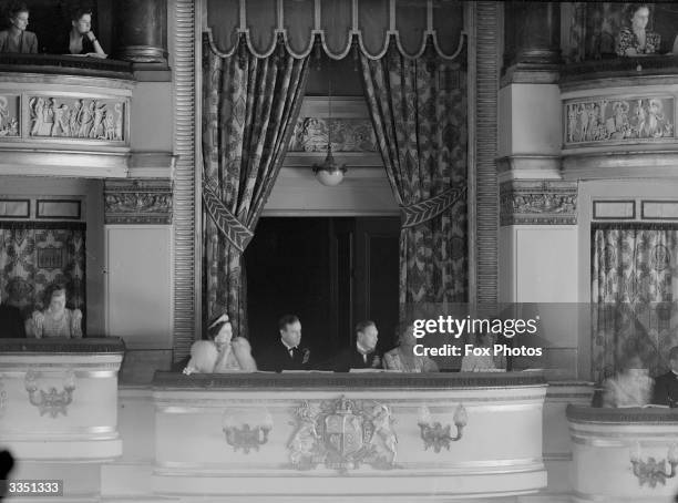 Members of the British Monarchy watching a performance of 'Pacific 1860' fromn the Royal Box of the Drury Lane Theatre, London in aid of King...