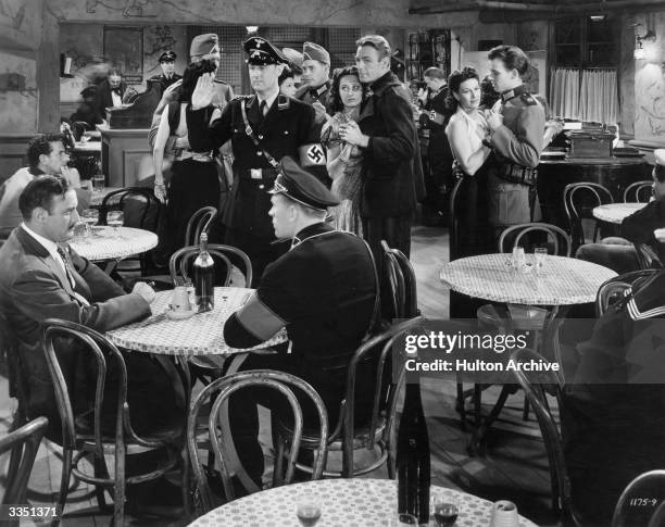 Randolph Scott eludes the Gestapo by dancing with a regular of La Coquin Cafe, in a scene from the Universal picture 'Paris Calling'.