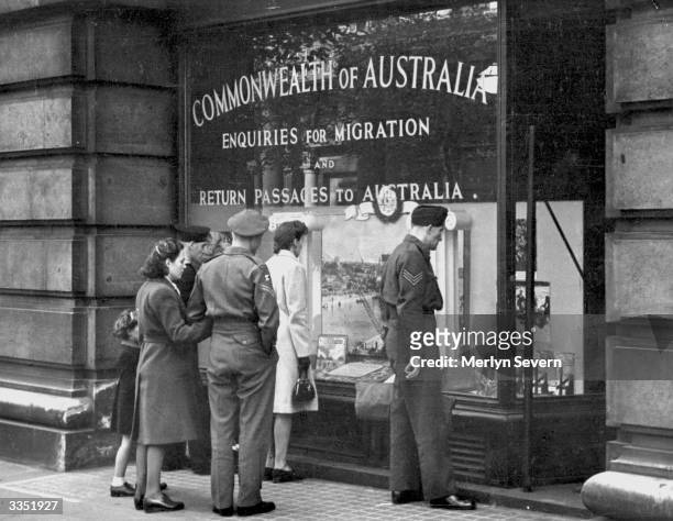 Private Ian Hamilton Clark of the Australian Imperial Force and his Russian wife Olga contemplate a window display in London offering passages to...