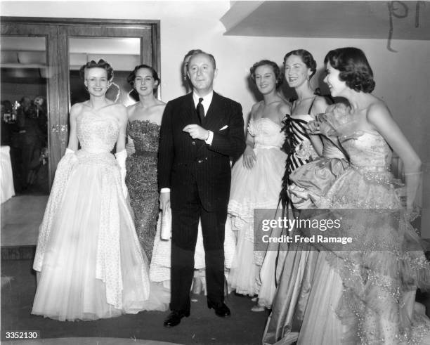 Fashion couturier Christian Dior , designer of the 'New Look' and the 'A-line', with six of his models after a fashion parade at the Savoy Hotel,...