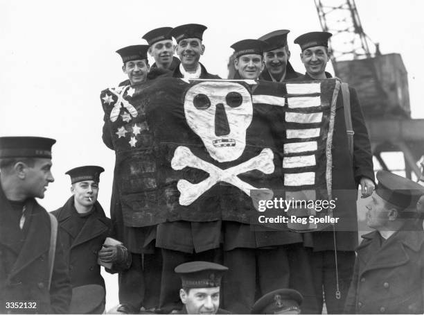 Waving a Jolly Roger, the crew of the submarine Thrasher on their return to port after a successful foray against enemy ships. She was known as the...