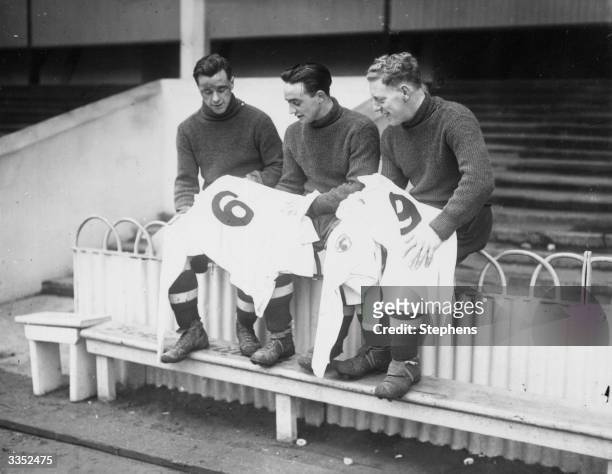 Three Tottenham Hotspur FC soccer players looking at their new numbered football shirts for the third round FA cup tie against Watford at White Hart...