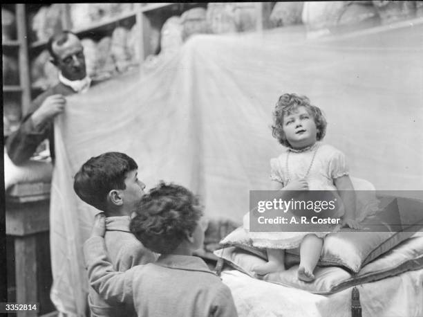 Two young boys stare at a waxwork model of Princess Elizabeth at Madame Tussaud's waxworks in London.