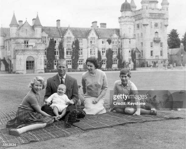Queen Elizabeth II and Prince Philip, Duke of Edinburgh with their children, Prince Andrew , Princess Anne and Charles, Prince of Wales sitting on a...