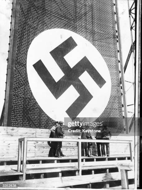 One of the huge swastika signs being hung during preparations for a May Day rally where Hitler will address a crowd of nearly 2 000 in the Tempelhof...