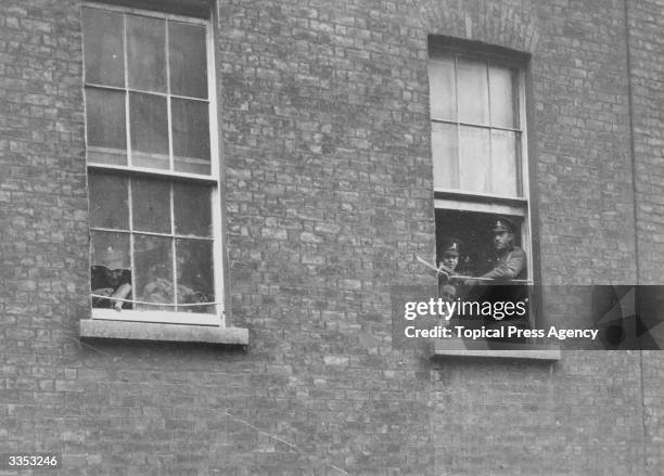 British soldier on sentry duty at a window in Dublin Castle. He is keeping a watch out for Sinn Fein's Irish Volunteers who are waging a guerilla...