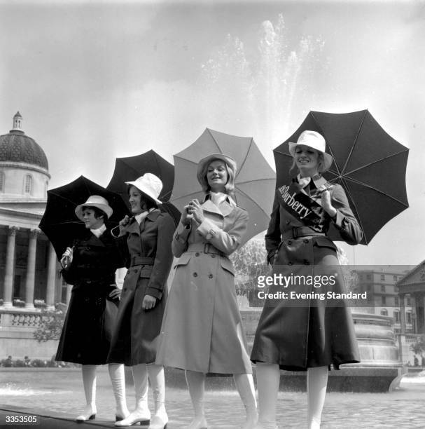 Brenda Capwell, this year's 'Miss Burberry' poses in London's Trafalgar Square with three other models in Burberry fashions.