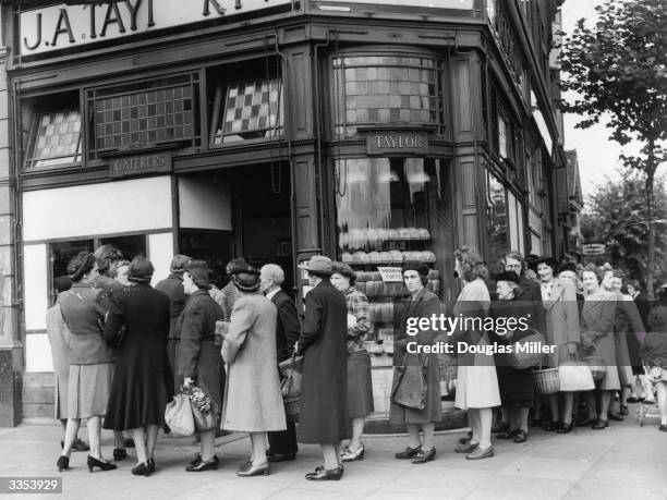 Queues forming outside a bakery in Streatham High Street, London, on the last day before bread rationing is introduced.