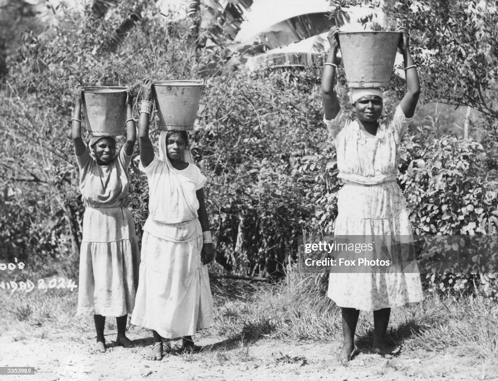 Bucket Woman Women carrying buckets of water on their heads on the island of ...