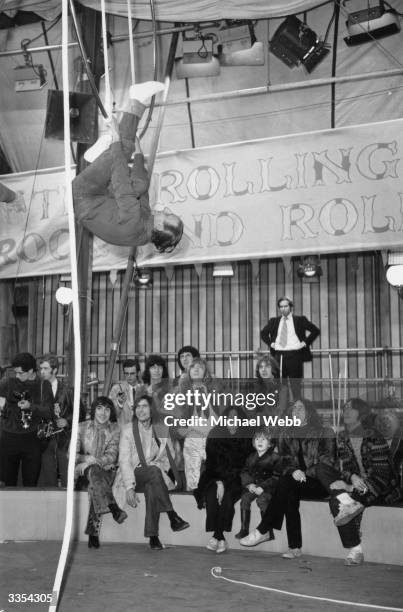 Watching a trapeze artist at Internel Studios in Stonebridge Park, Wembley, during a rehearsal for a TV spectacular The Rolling Stones Rock and Roll...