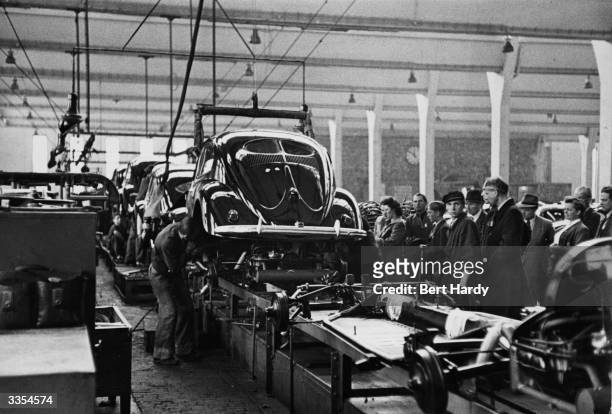 Workers at the chassis stage on the VW Beetle production line at the Volkswagen factory at Wolfsburg, Germany. Original Publication: Picture Post -...