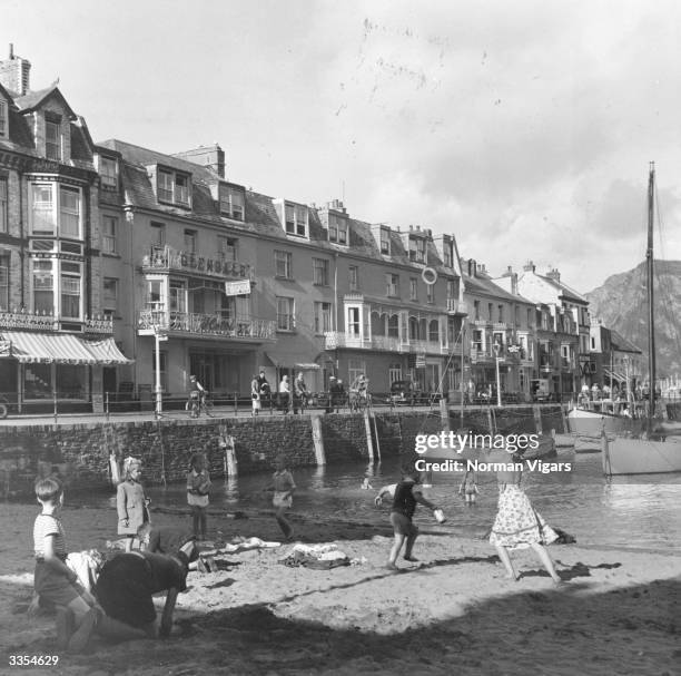 Children playing on a small harbour beach in the centre of Ilfracombe, Devon.