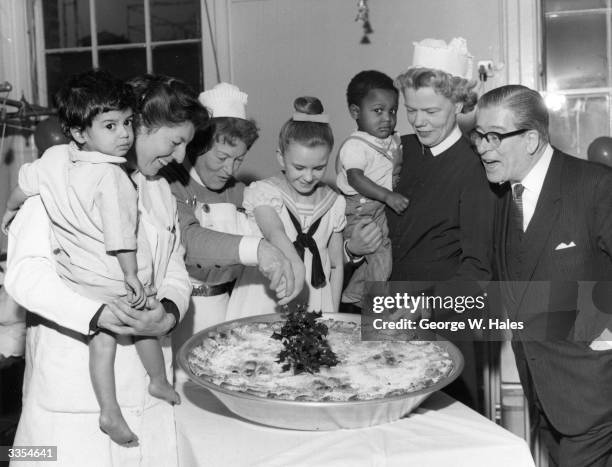 London's largest mince pie weighing 46 lbs and measuring over 2 feet across being donated to the children's ward of West London Hospital at...