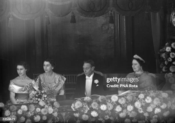 King George VI watching the Royal Command Performance at the London Palladium with Queen Elizabeth and their daughters Princesses Margaret Rose and...