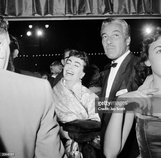 American actress Joan Crawford with actor Cesar Romero at the film premiere of 'A Star Is Born' featuring Judy Garland.