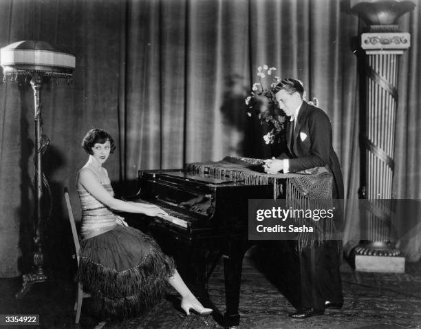 Dancer and pianist Diana Harris serenades fellow dancer Fred Trevor.