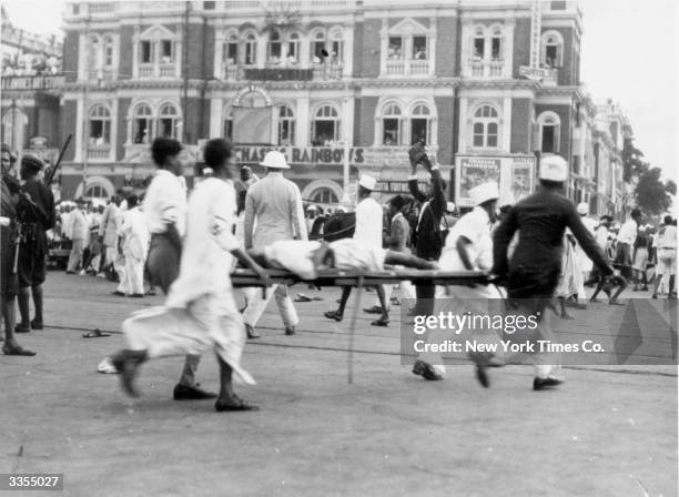 An injured man being taken away on a stretcher during the Bombay riots, India. Original Publication: Picture Post - 1057 - India - What Civil...