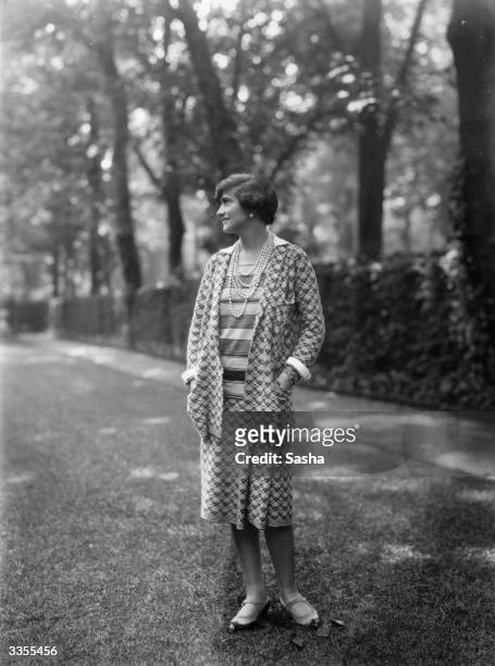 Designer Gabrielle 'Coco' Chanel , wearing one of her suits in the grounds at Fauborg, St Honore, Paris.