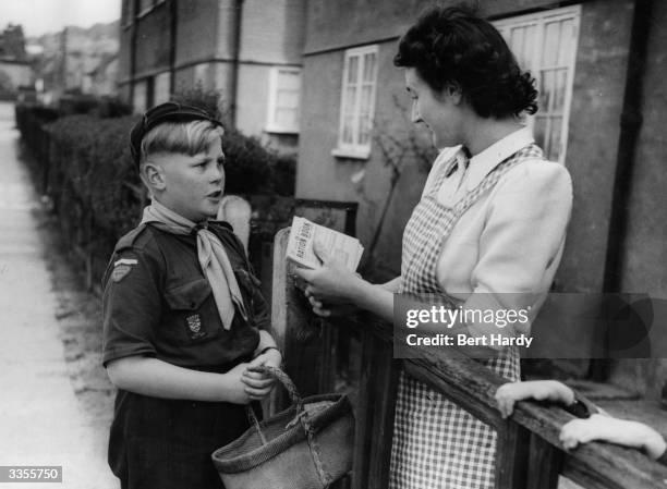 British boy scout about to embark on a shopping trip for a neighbour during the Boy Scout Association's annual 'Bob A Job' fundraising week when...