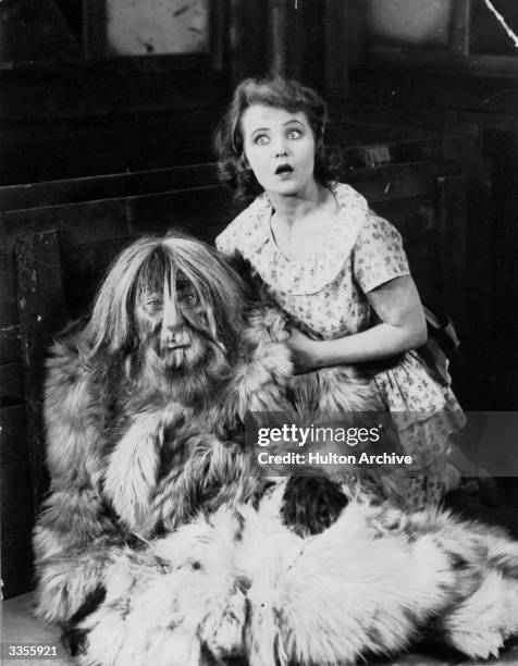 Startled woman clutches a man in a furry beast costume, from an unknown film.