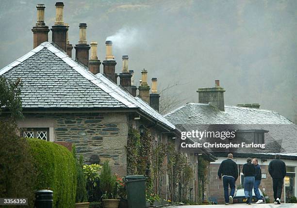 Tourists barve the inclement weather April 13, 2004 during a visit to the village of Luss in Loch Lomond, Scotland. The famous Scottish beauty spot...