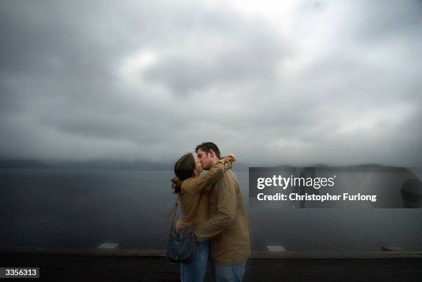 Young couple brave the rain April 13, 2004 during a visit to the village of Luss in Loch Lomond, Scotland. The famous Scottish beauty spot of Loch...