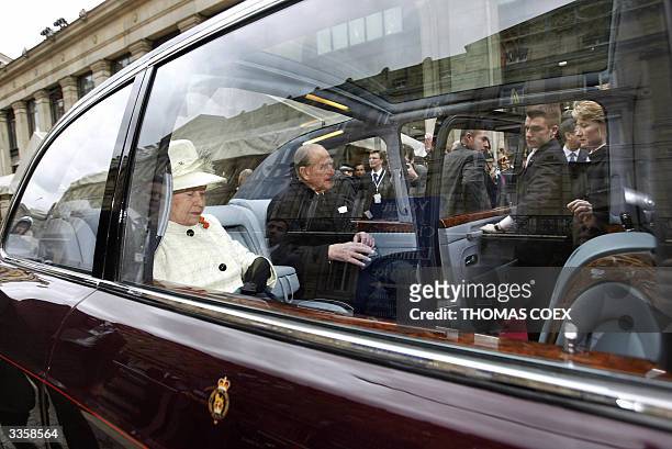 Queen Elizabeth II and her husband Prince Philip sit in a limousine at the Gare du Nord train station in Paris, 05 April 2004, at the start of a...
