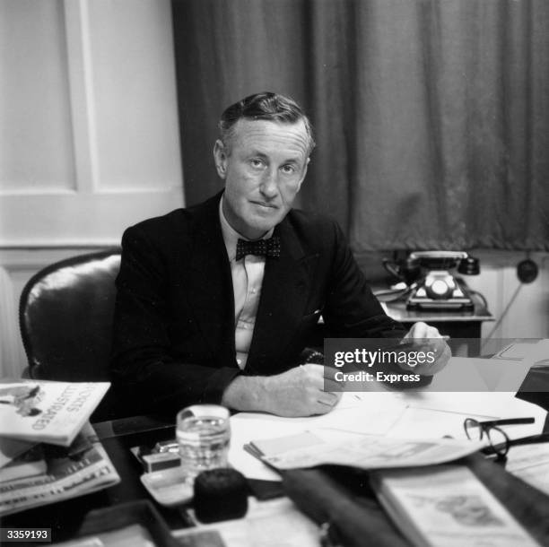 Ian Fleming, British author and creator of James Bond, at his desk in his study.