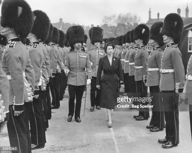 Princess Elizabeth inspects the troops of the 3rd Battalion Grenadier Guards, of whom she is a colonel, at Chelsea Barracks, London.