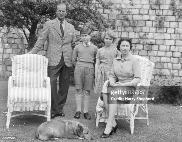 Queen Elizabeth II and The Prince Philip, Duke of Edinburgh relaxing with their children, Prince Charles and Princess Anne, in the grounds of Windsor...