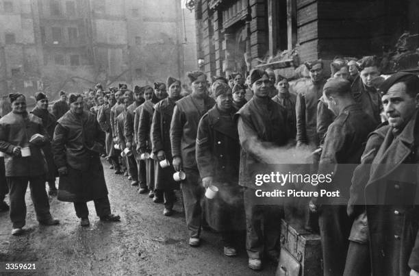 Demolition workers queuing for a hot cup of tea during their work demolishing bomb damaged buildings in London. Original Publication: Picture Post -...