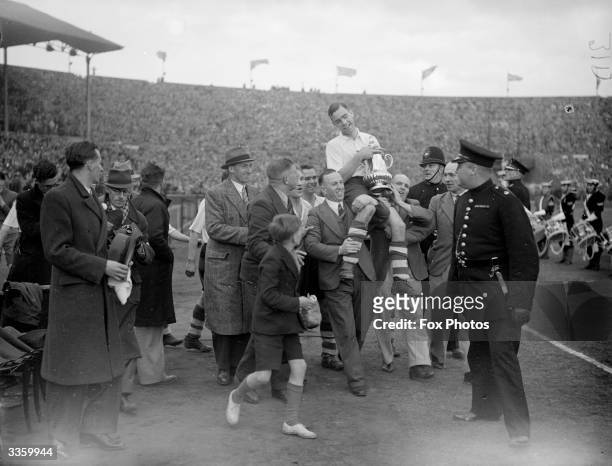 Preston North End captain T Smith, with the FA Cup trophy, is aloft by supporters, after Preston North End's 1-0 victory over Huddersfield Town in...
