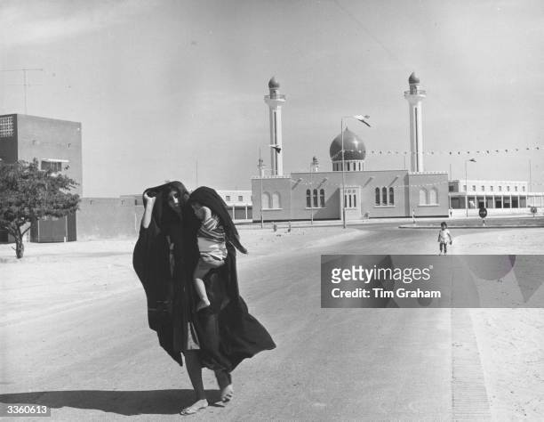 New residents of the recently built town of Isa, Bahrain, with one of the two new mosques.