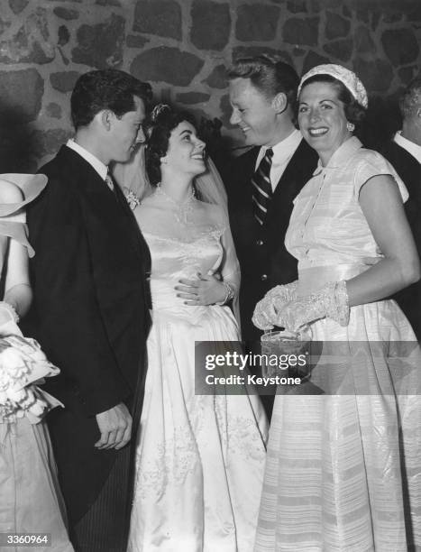 Screen star Van Johnson and his wife Evie congratulate Elizabeth Taylor and her husband Conrad Hilton at their wedding reception in Beverly Hills,...