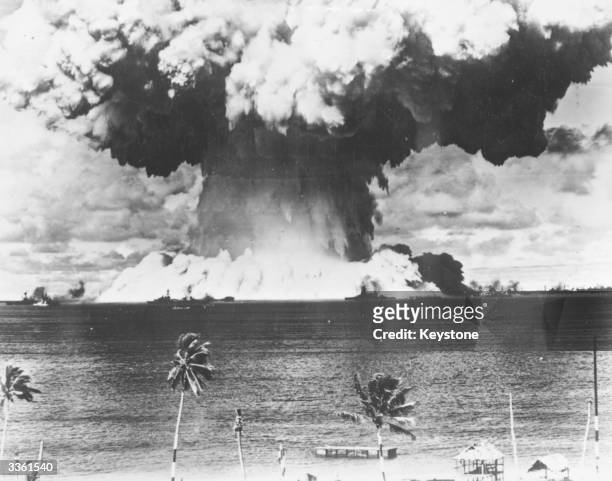 Mushroom cloud rises from the waters of Bikini Lagoon during the United States first series of underwater atomic tests. Ships of a 'Guinea Pig' fleet...