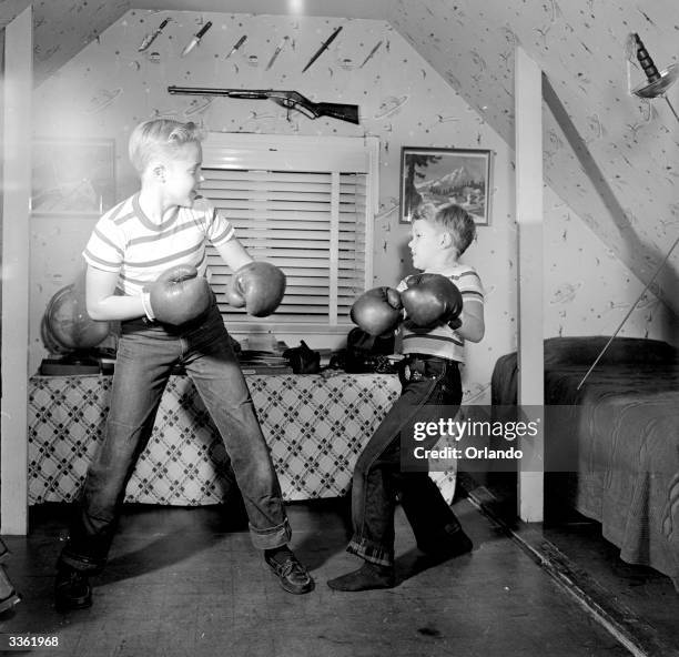 Television stars Ronnie and Glenn Walken boxing in the attic of their home in Bayside, Long Island.