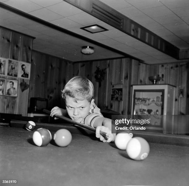 Young television star Glenn Walken cues up a shot during a game of pool at home in Bayside, Long Island.