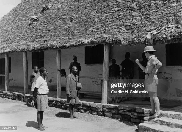 Belgian territorial agent addresses two indigenous inhabitants in the Belgian Congo.