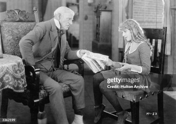 American actress Mary Pickford receiving a handful of banknotes in a scene from the film 'Little Lord Fauntleroy'.