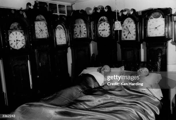 Mr and Mrs Charles Bromley of Belper, Derbyshire, at home with part of their collection of 109 grandfather clocks.