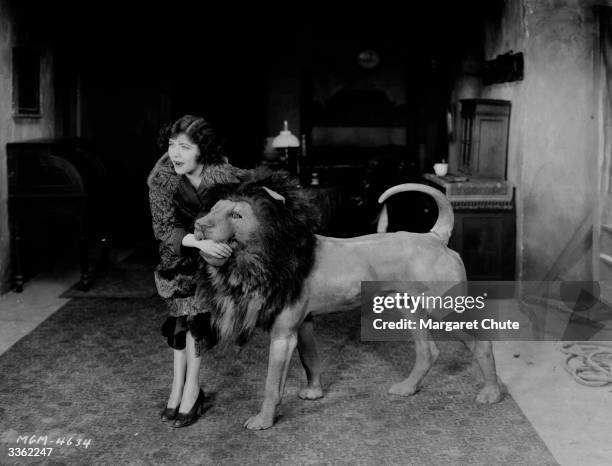 The actress Renee Adoree plays with a stuffed lion during a break in the filming of, 'The Show' in which she stars with John Gilbert.