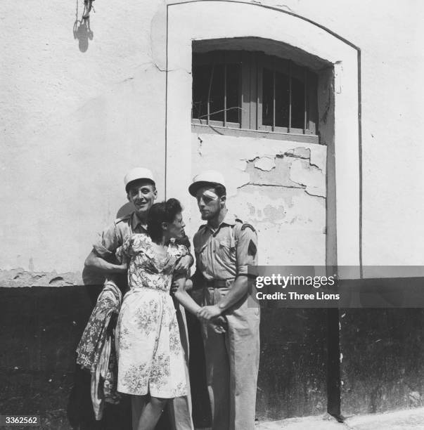 Local girl is arrested by two members of the French Foreign Legion, who have their headquarters here in Sidi Bel Abbes, Algeria.