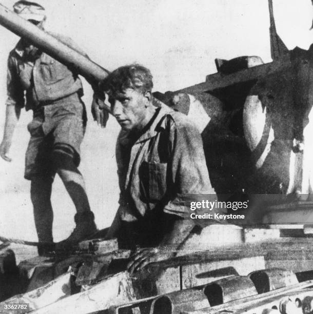 British soldier emerges from his tank on the North African front into the hands of the enemy.