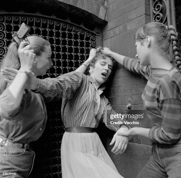 Members of a teenage girl gang convincing an unwilling recruit to join the gang.