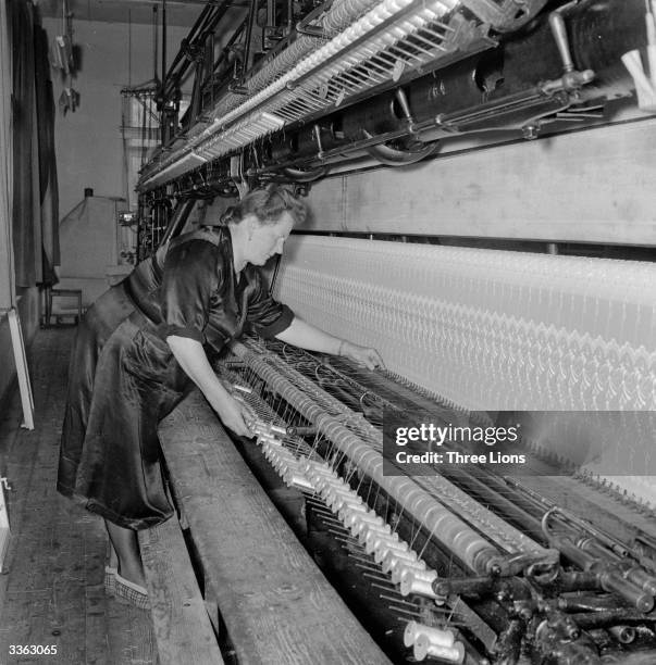 Worker at the Lustenau textile mill in Vorarlberg, Austria, operates an embroidery machine which weaves a single piece of fabric eleven yards wide.