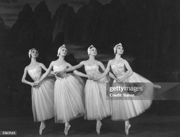 Four cygnets dancing in a production of Swan Lake at Sadler's Wells Theatre, London.